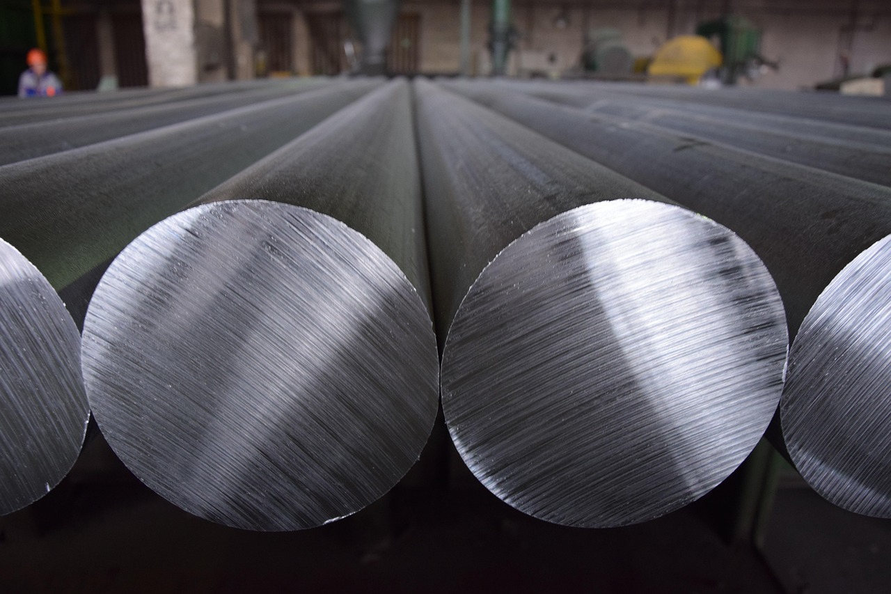 Aluminio vs PVC. Varillas de aluminio cilíndricas en un entorno industrial.